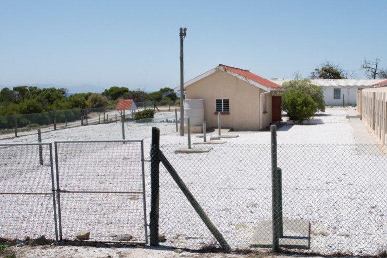 A view of the one-roomed prison building (L) where Robert Sobukwe, a Pan-Africanist Anti-Apartheid activist was kept in solitary confinement on Robben Island, where Nelson Mandela, an anti-apartheid revolutionary and the former president of South Africa, spent 18 of the 27 years he was imprisoned, on January 16, 2020. The Robben Island prison is now a museum dedicated to showing visitors the brutal conditions under which the prisoners lived, but also how important the island became as a base to counter the Apartheid regime. Nelson Mandela was released from prison after 27 years on February 11, 1990, and went to win the Nobel Peace prize and become the first President of democratic South Africa. (Photo by RODGER BOSCH / AFP)