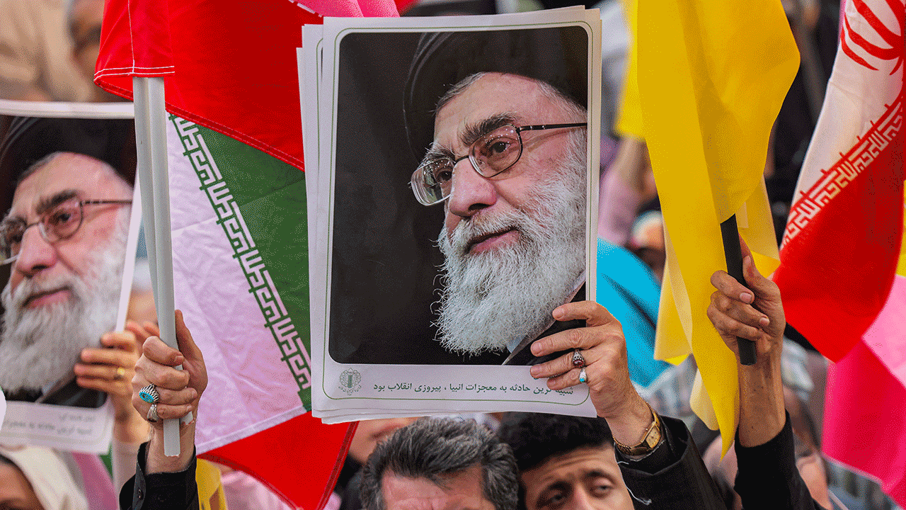 A demonstrator holding a picture of Iran's Supreme Leader Ayatollah Ali Khamenei at a rally in Tehran