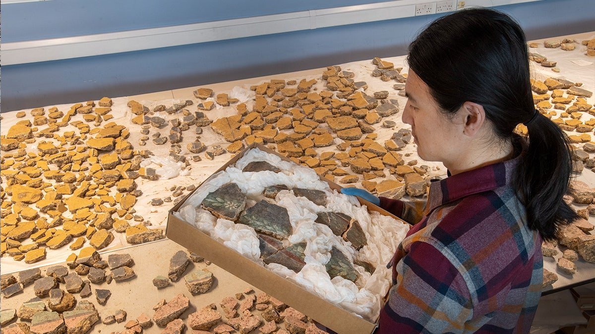 Han Li holding box of fragments
