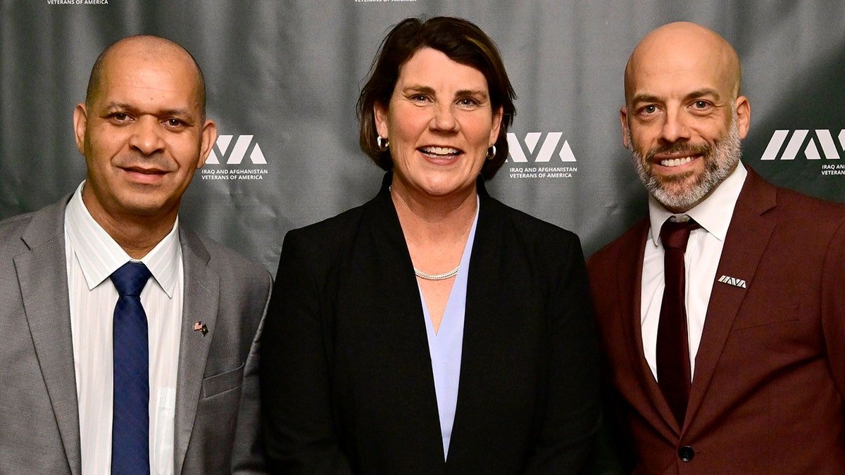 Amy McGrath poses for photo between two other people