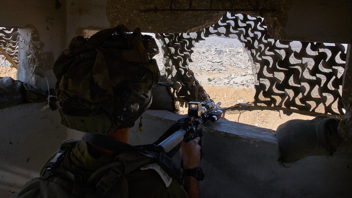 Israeli soldier aims weapon in Gaza