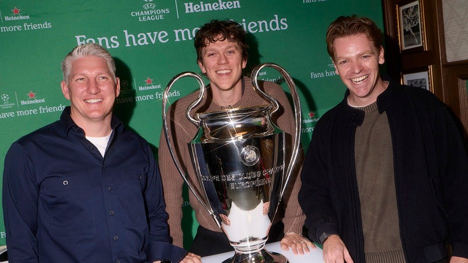 Soccer fans in front of UEFA Champions League Trophy