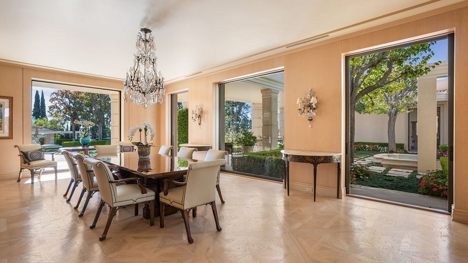 The dining room features many floor to ceiling glass doors leading to the backyard.