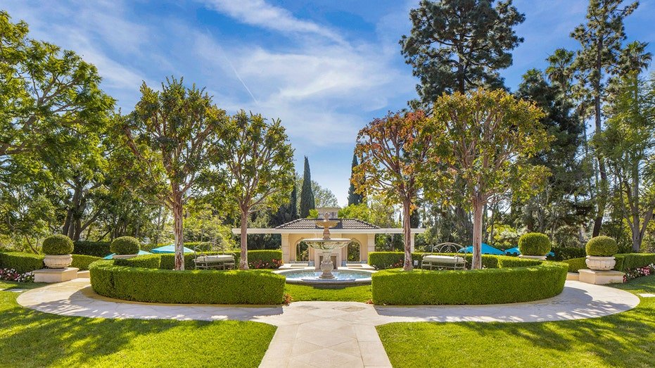 The grounds feature manicured lawns and a fountain.