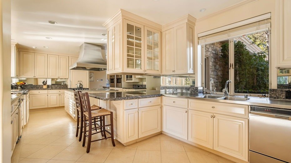 The gourmet kitchen features a large window looking out onto the grounds.