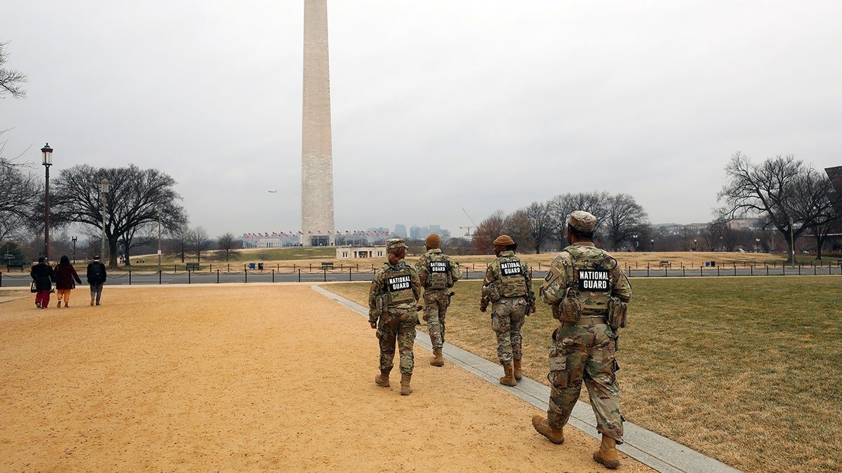 National Guard troops walk toward Washington Monument