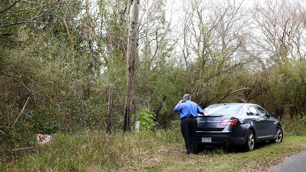 An investigator next to his cop cat at a crime scene.