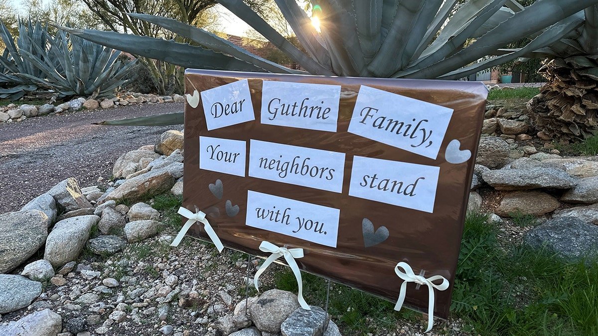 A supportive sign from neighbors posted on a fence outside Nancy Guthrie's home.