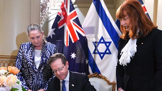 Israeli President Isaac Herzog signing the Government House guest book.