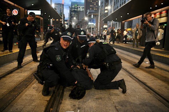 Multiple people were arrested at the Town Hall protest. Peeters is in the background on the right, photographing the action.