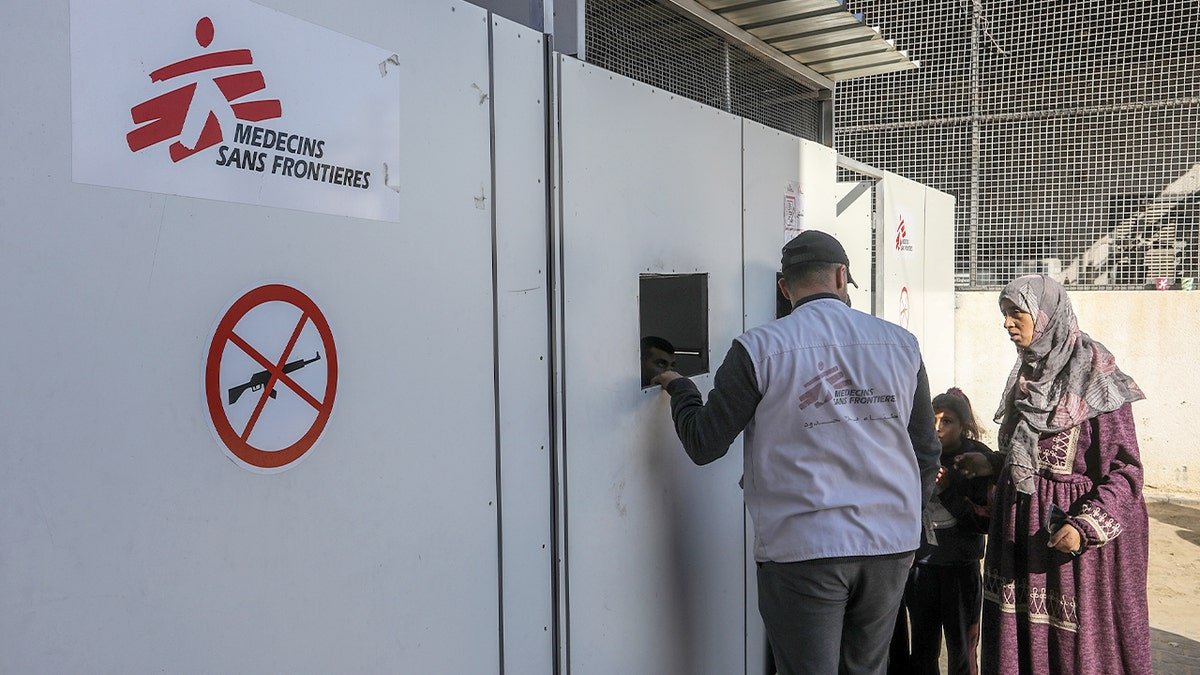 A Doctors Without Borders employee speaks with a patient inside a hospital ward operating with scarce resources.