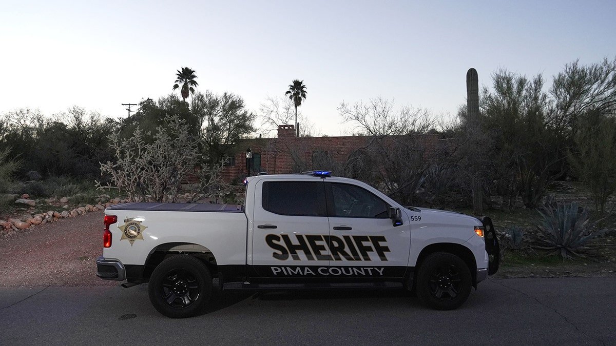 A member of the Pima County Sheriff's office standing outside Nancy Guthrie‘s house.