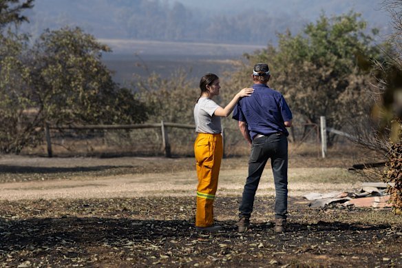 Resident Robbie Cumming (right) is comforted after seeing the ruins of his home near Yarck in January 2026.