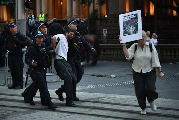 Police arrest one protester on George Street.