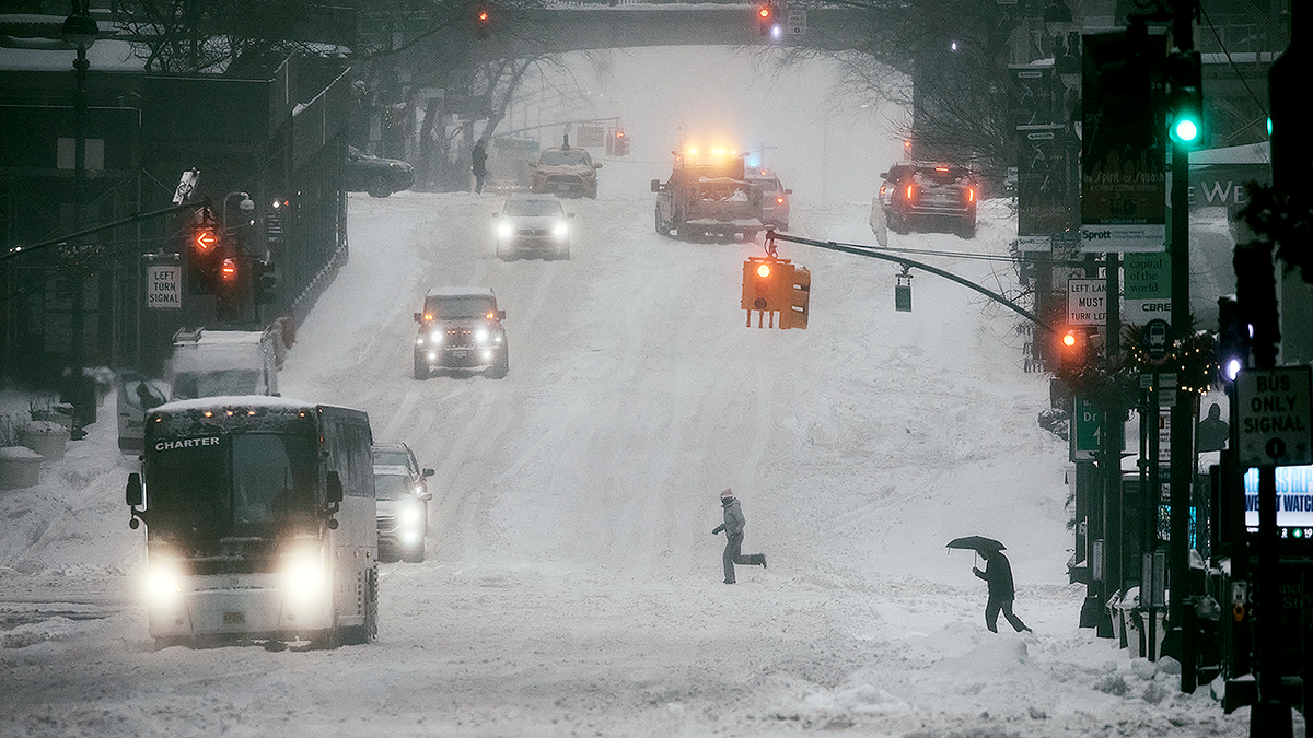 Buses in snow with cars.