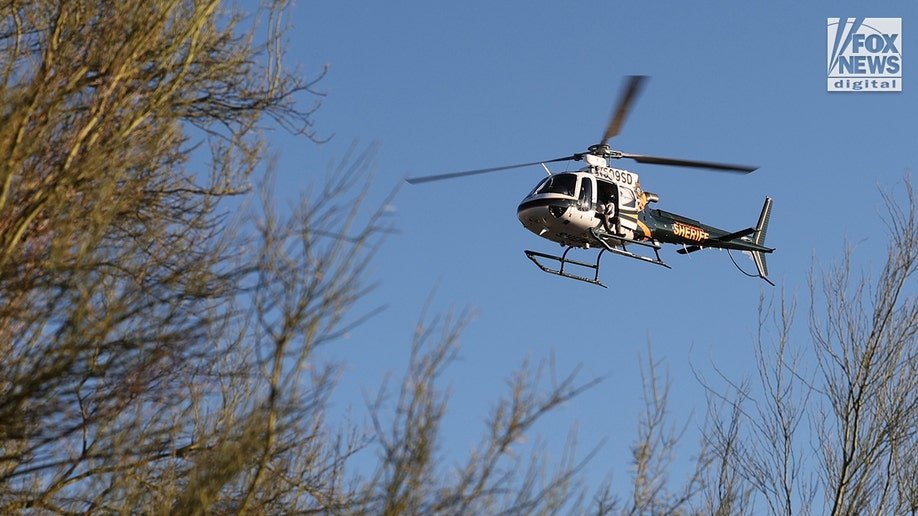 Nancy Guthrie's disappearance leads to a Pima County Sheriff helicopter flying over a desert landscape during a search operation for her