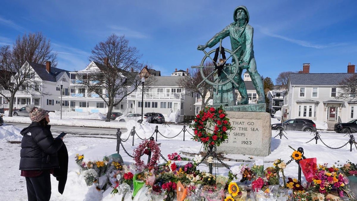 Christine Porper of Gloucester, Mass. pauses at the fisherman's memorial near the homeport of a fishing boat that went missing with seven onboard, Monday, Feb. 2, 2026, in Gloucester, Mass. (AP Photo/Charles Krupa)