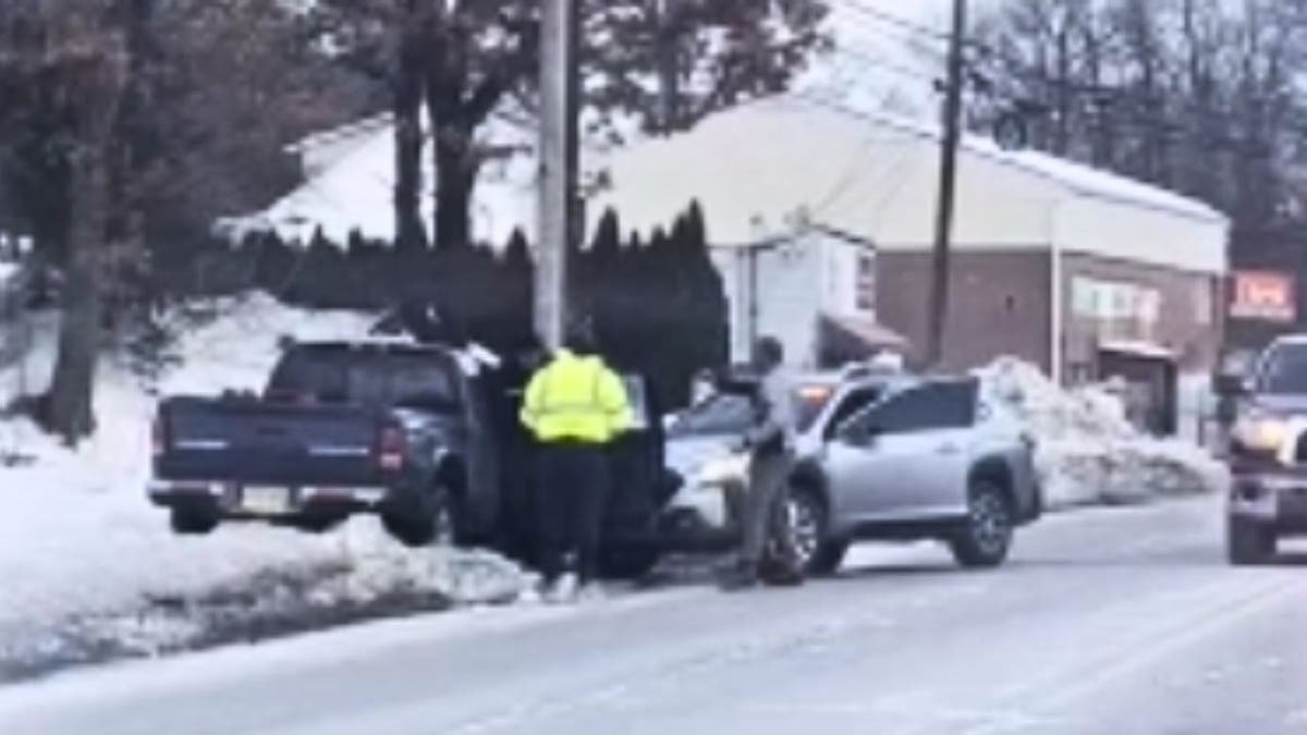 Man raising his hands beside a pickup truck after a crash during an ICE arrest attempt in New Jersey.