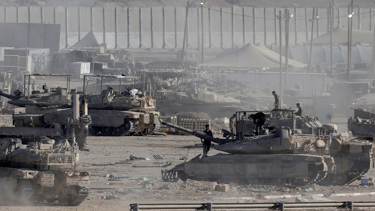 Israeli soldiers stand on military vehicles