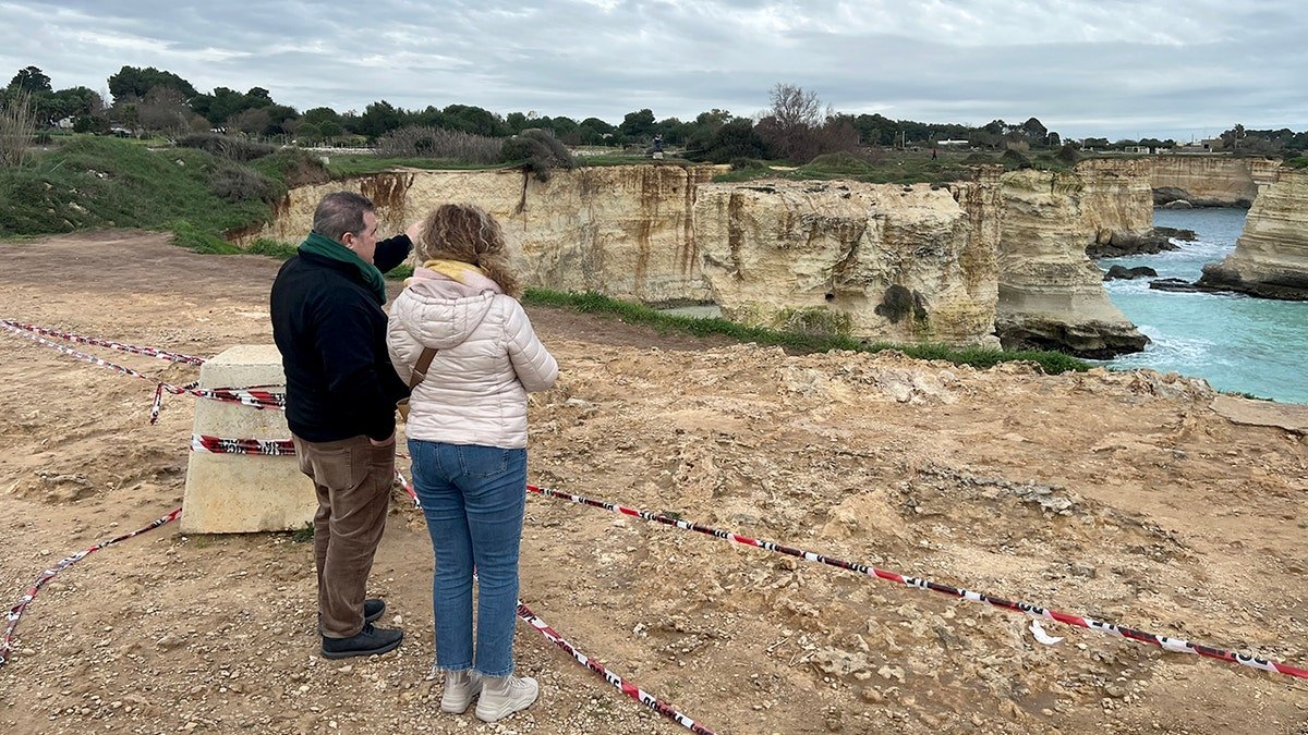 People stand near where Lovers' Arch collapsed in Italy