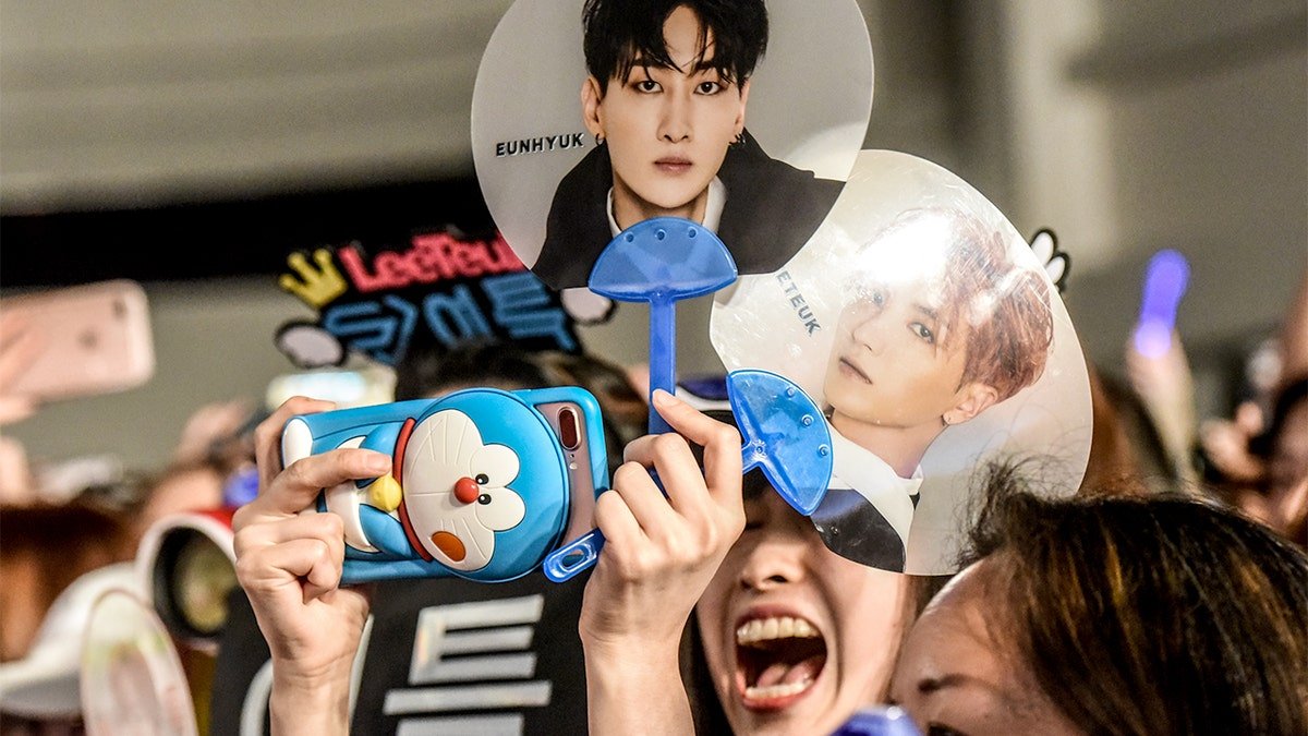 K-pop fans gather inside a large venue for a music convention.