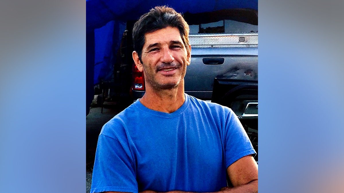 Kurt Van Dyke in blue shirt smiling with arms folded for a photo