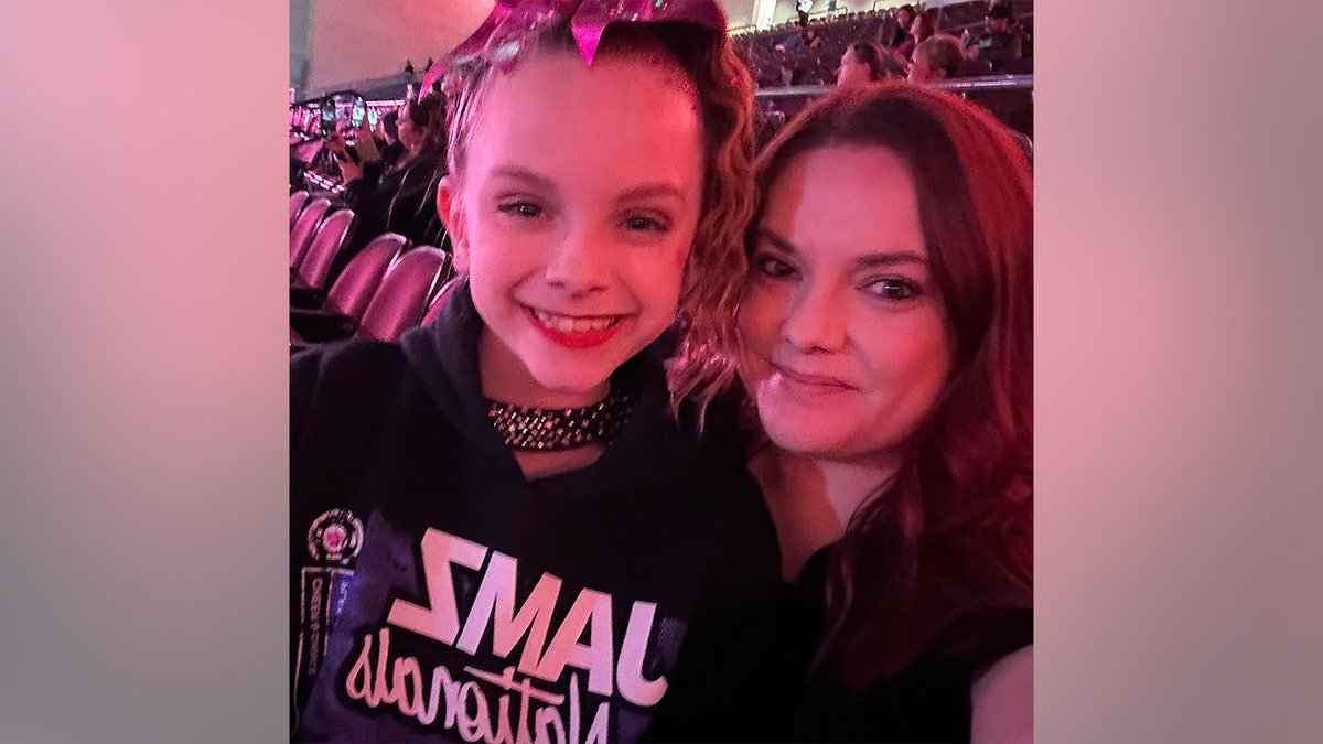 Tawnia McGeehan and Addi Smith smiling together for a close-up selfie inside a stadium or arena
