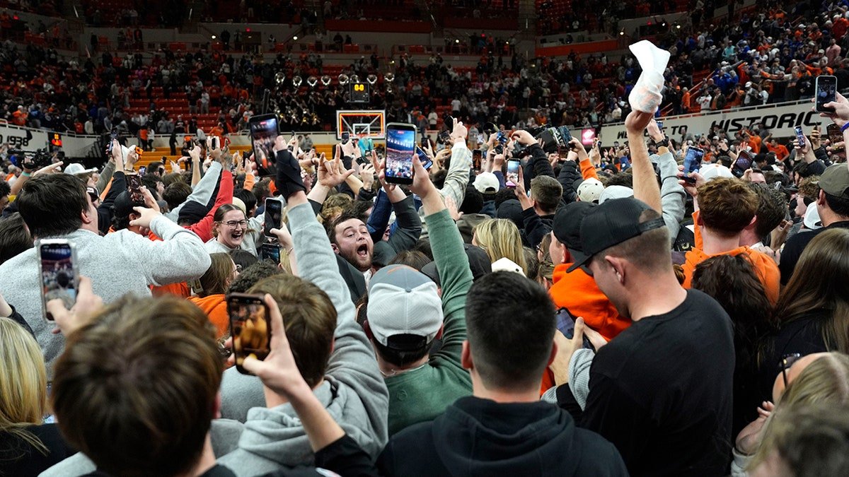 Oklahoma State fans rush the basketball court