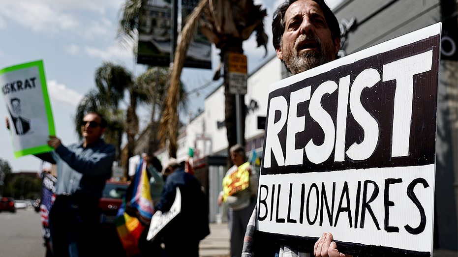 Anti-billionaire protester holding sign