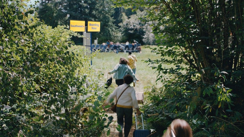 Passengers run into a field with seats in the middle