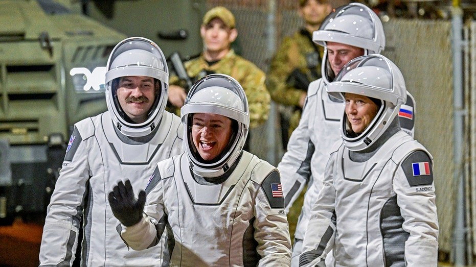 NASA's SpaceX Crew-12 crew members wave as they prepare for launch
