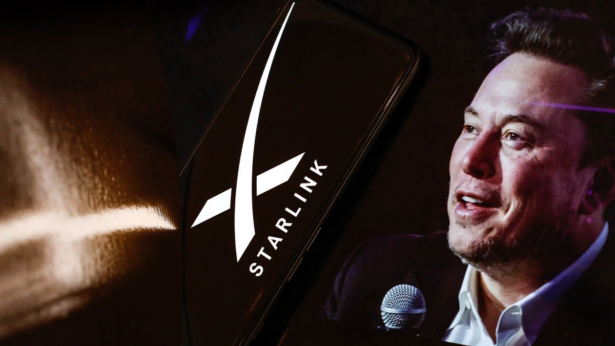 starlink logo on phone near portrait of elon musk