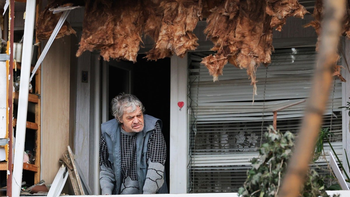 Ukrainian man near damaged balcony in Zaporizhzhia