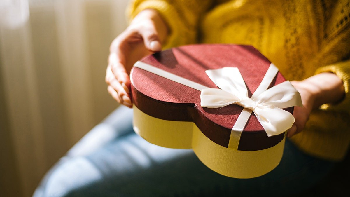 Young woman holding valentine day gift box
