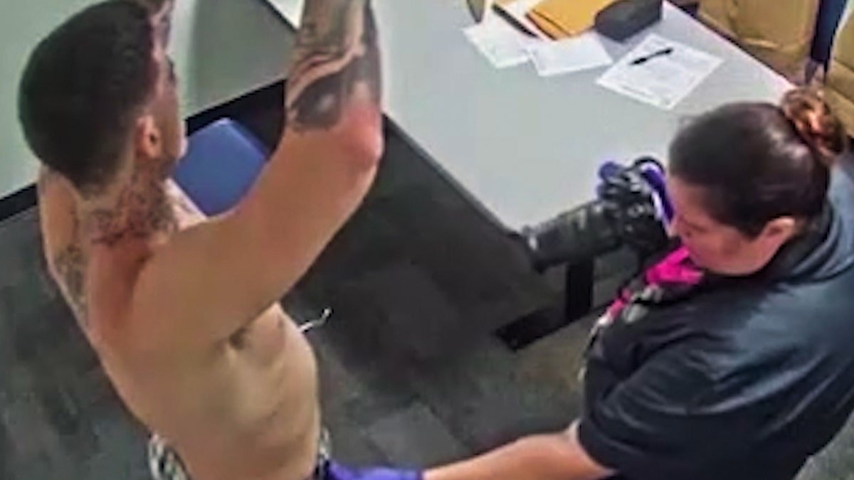 Wade Wilson being examined by a police officer.