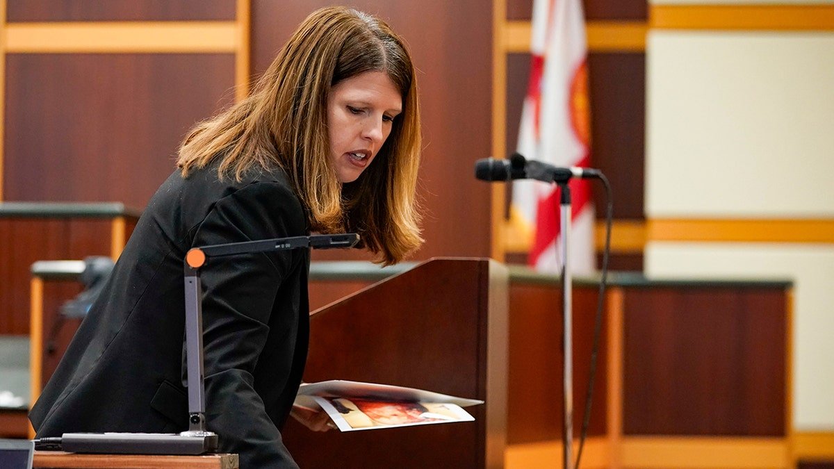 Assistant State Attorney Sara Miller placing photos on a desk in court.