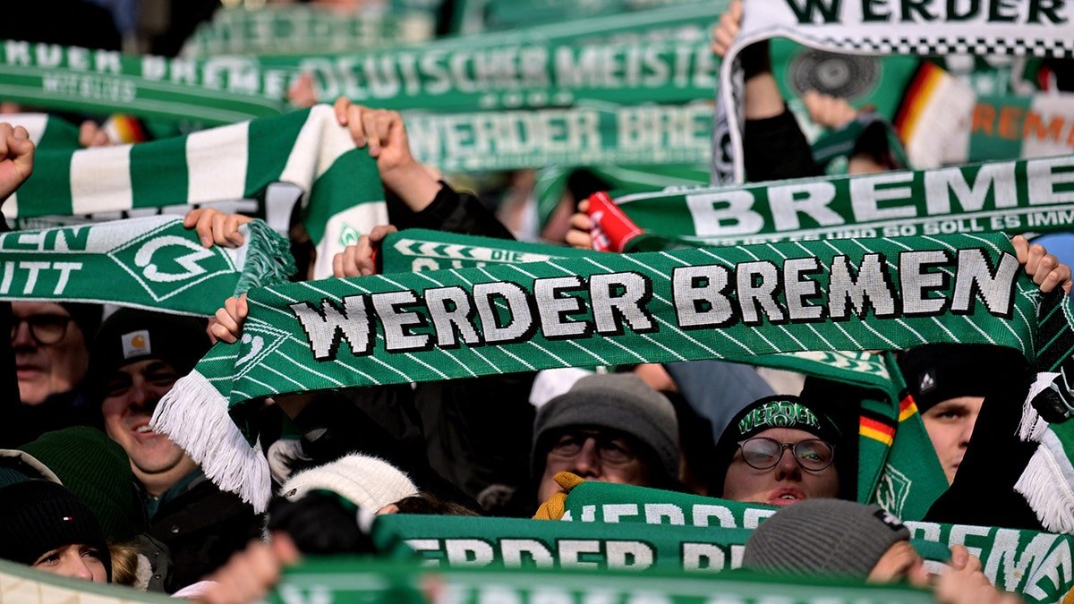 Werder Bremen fans hold scarves up