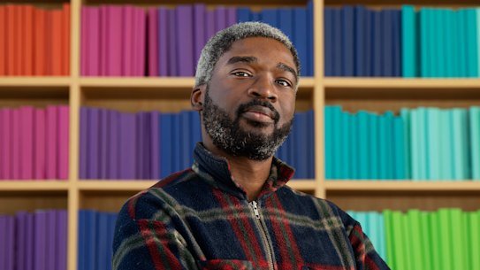 Joseph Damilare at the Green Square library he visits before or after work each day.  