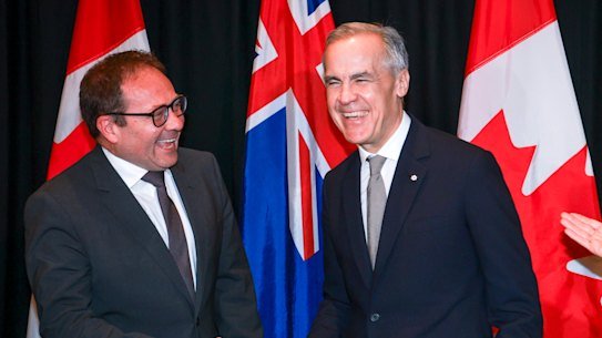 Canadian Prime Minister Mark Carney, centre, with Assistant Treasurer Daniel Mulino,