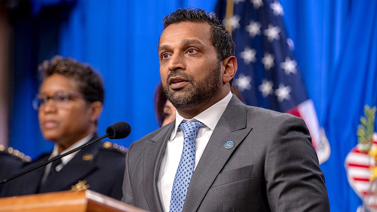 FBI Director Kash Patel speaks at a podium during a news conference inside the Justice Department.