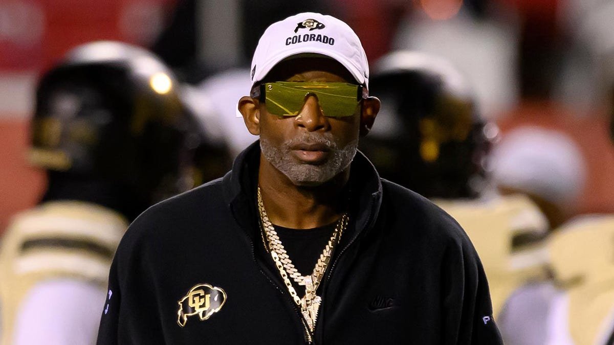 Deion Sanders watches his players warm up