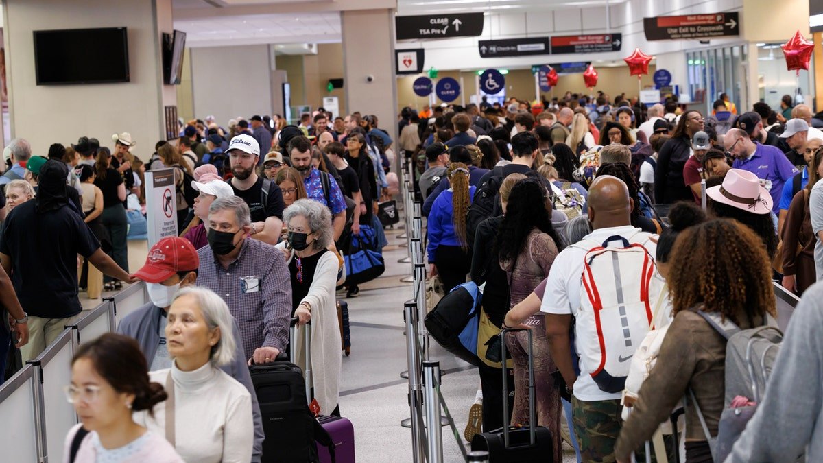 Flight passengers wait in long TSA line at Houston Airport.