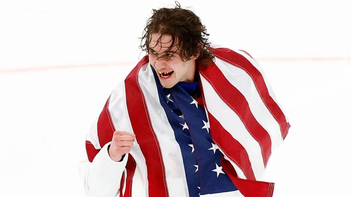 Jack Hughes holds the American flag