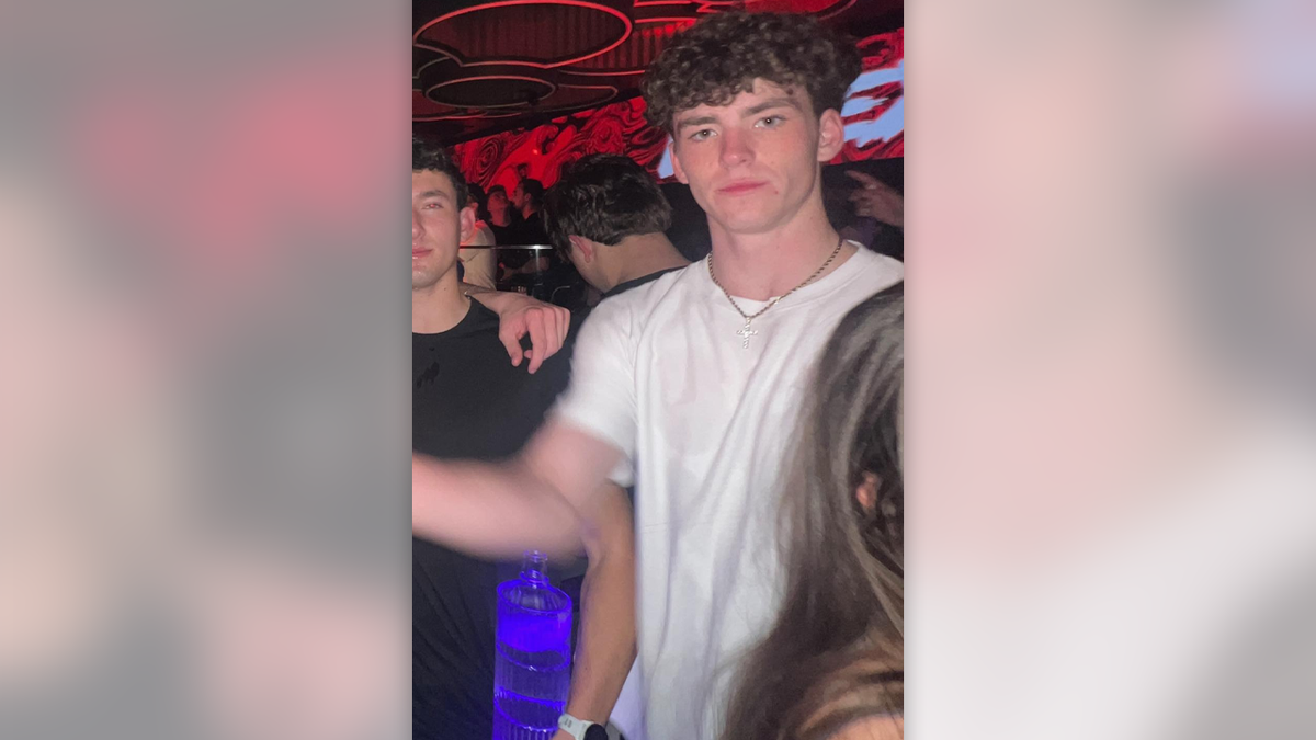 Jimmy Gracey has curly hair in the Shoko nightclub where he was last seen, wearing a white T-shirt and gold chain with a rhinestone cross