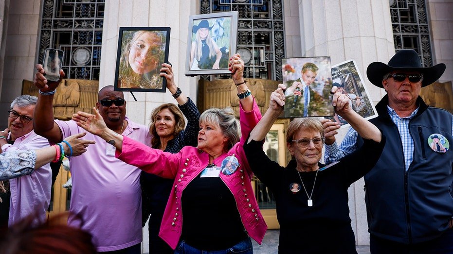 The family of victims raise photographs outside Social Media Trial