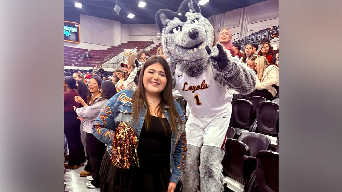 Loyola student Sheridan Gorman poses with Loyola's mascot at a game.