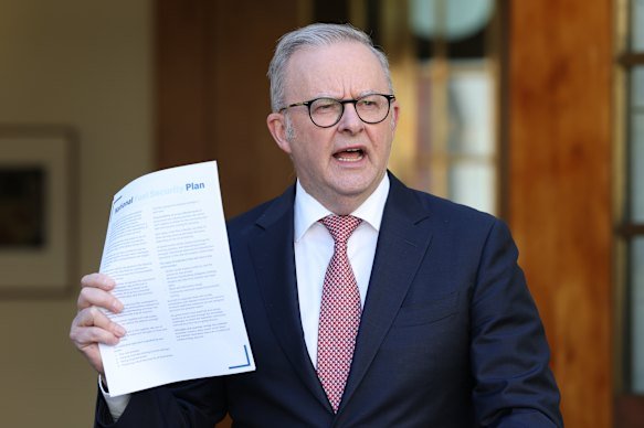 Prime Minister Anthony Albanese holds up a copy of the national fuel plan at Monday’s press conference.