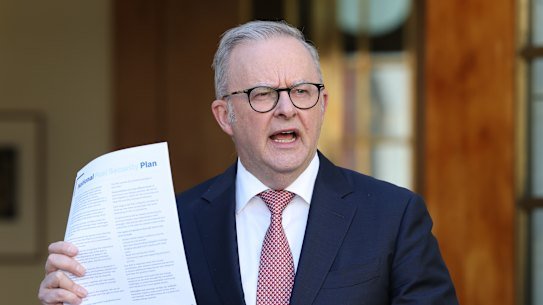 Prime Minister Anthony Albanese holds up a copy of the national fuel plan at Monday’s press conference.
