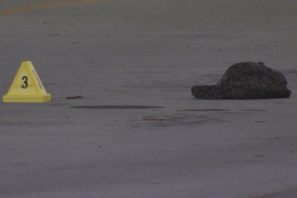An evidence marker sits with a police cap on the ground in Mernda. 