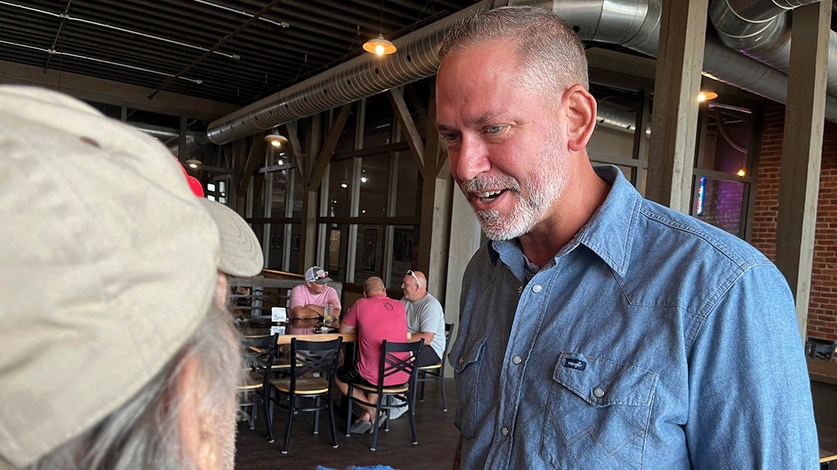 Independent Dan Osborn, a challenger to two-term Republican Sen. Deb Fischer in 2024, chats with guests at a brewery in Beatrice, Neb.